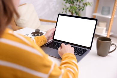 Photo of Woman working with laptop at white table indoors, closeup. Mockup for design