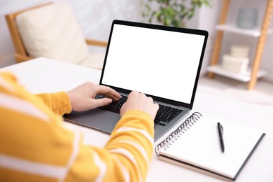 Photo of Woman working with laptop at white table indoors, closeup. Mockup for design