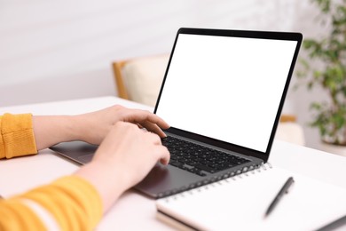 Photo of Woman working with laptop at white table indoors, closeup. Mockup for design