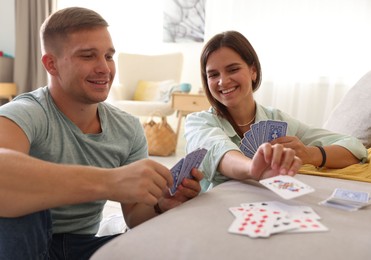 Photo of Man and woman playing cards at home