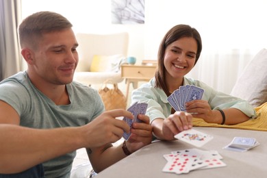 Photo of Man and woman playing cards at home