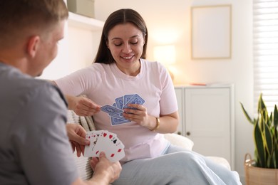 Photo of Man and woman playing cards on sofa at home