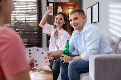 Photo of Friends playing cards at wooden table indoors