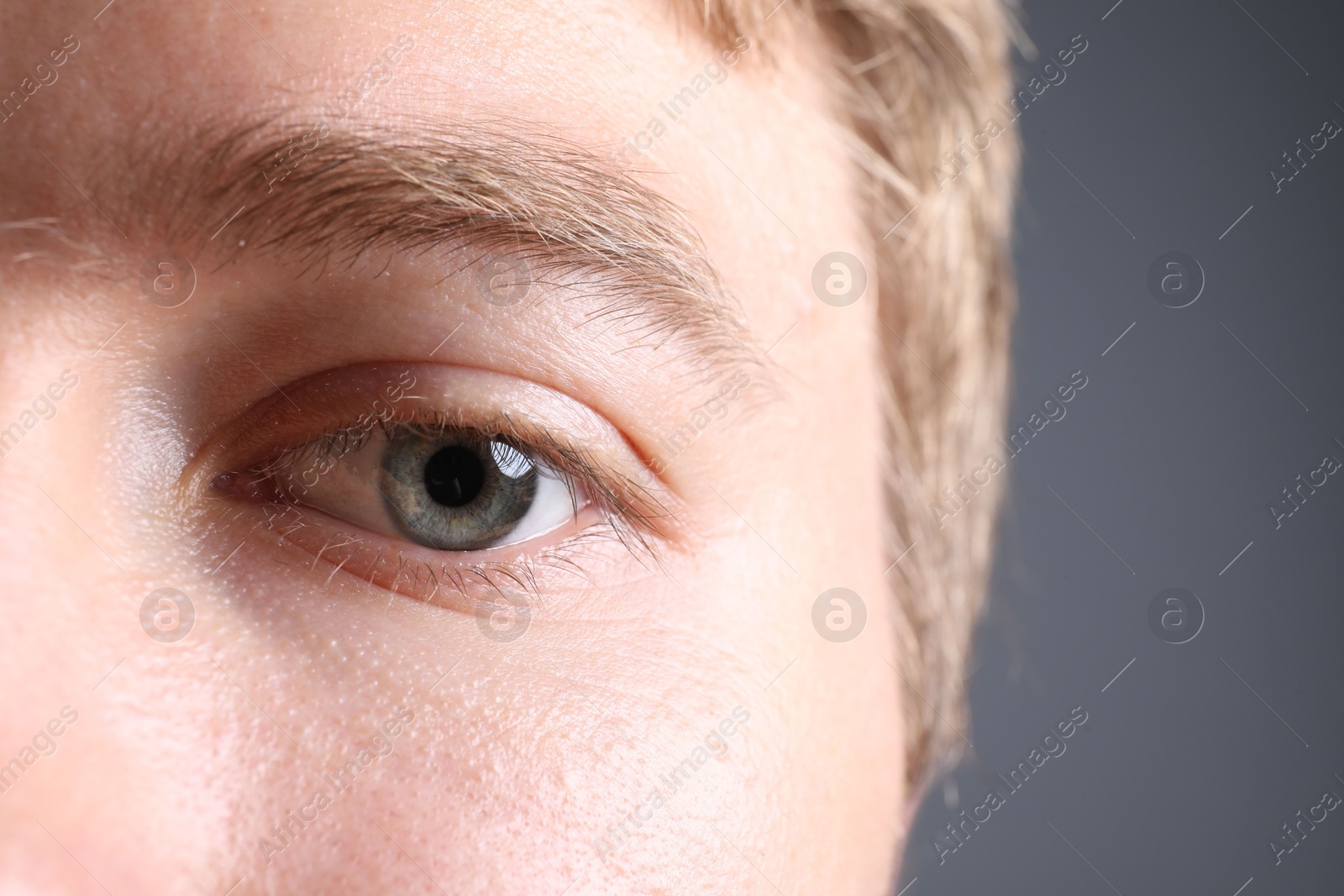 Photo of Man with beautiful eyes on grey background, closeup