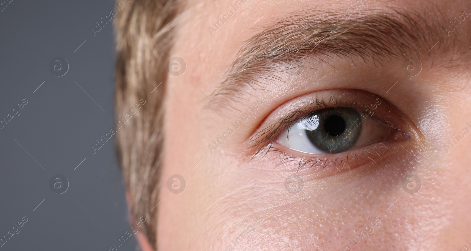 Photo of Man with beautiful eyes on grey background, closeup