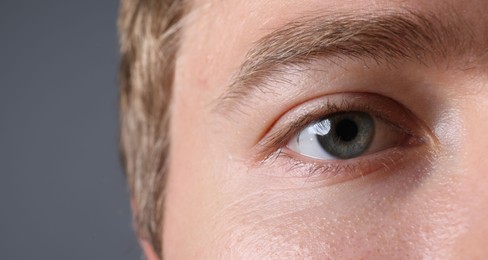 Photo of Man with beautiful eyes on grey background, closeup
