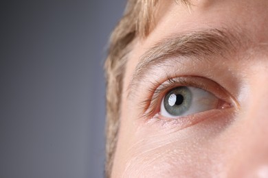 Photo of Man with beautiful eyes on light grey background, closeup. Space for text