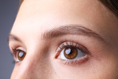 Photo of Woman with beautiful eyes on grey background, closeup