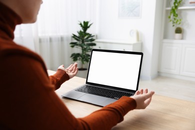 Photo of Woman working with laptop at wooden table indoors, closeup. Mockup for design
