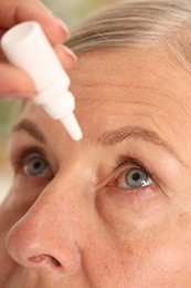 Photo of Woman applying eye drops on light background, closeup
