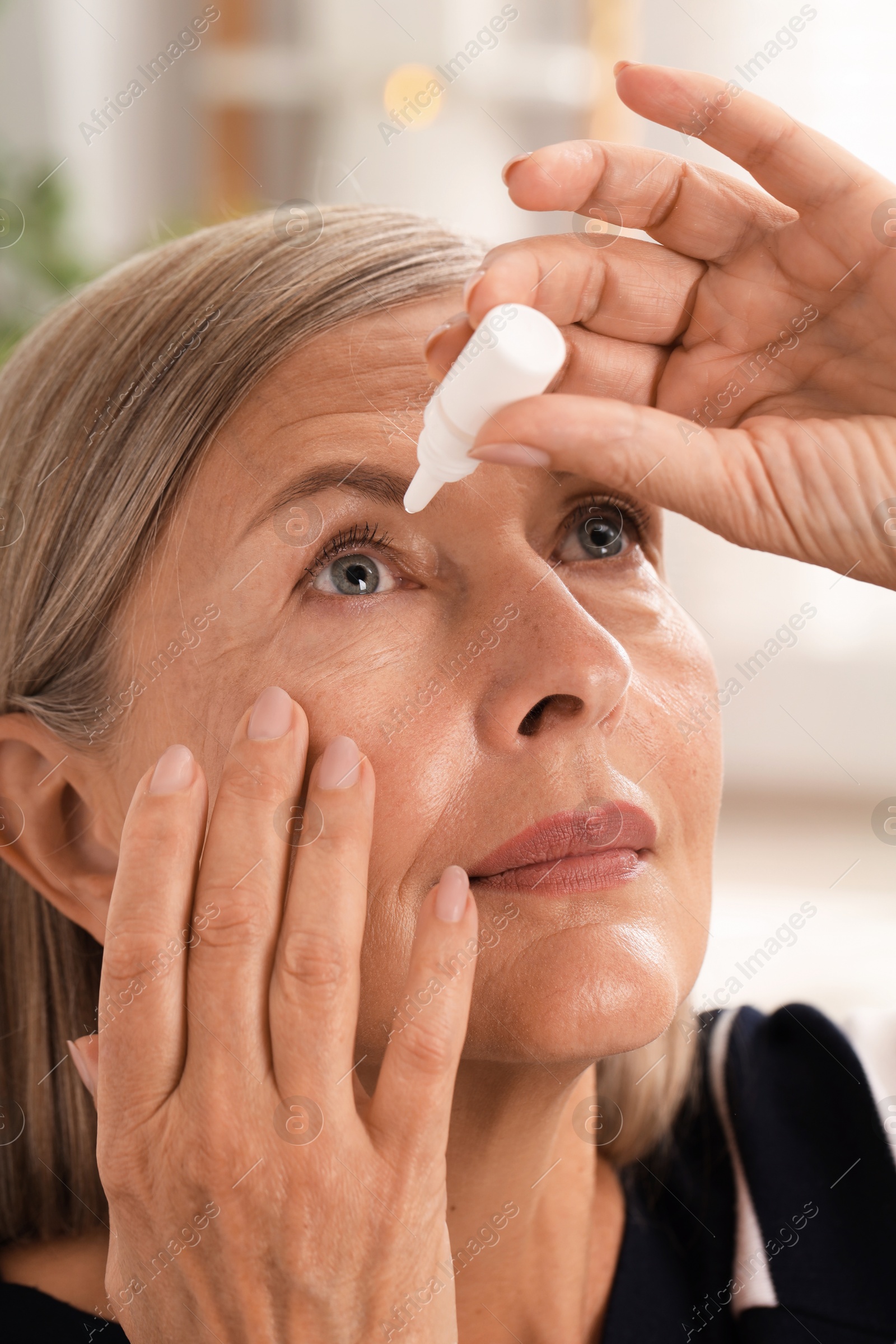 Photo of Senior woman applying eye drops at home