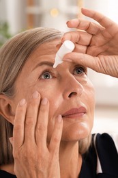 Photo of Senior woman applying eye drops at home