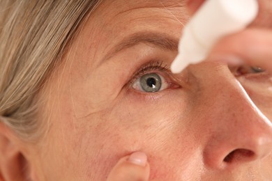 Photo of Senior woman applying eye drops, closeup view