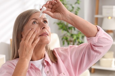 Photo of Senior woman applying eye drops at home