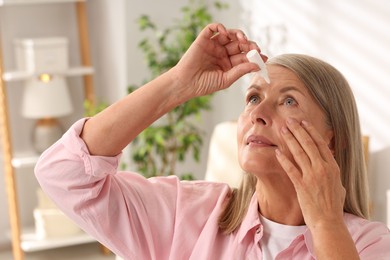 Photo of Senior woman applying eye drops at home