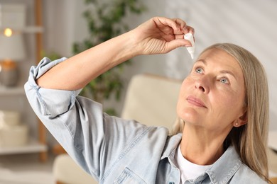 Photo of Senior woman applying eye drops at home