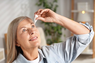 Photo of Senior woman applying eye drops at home