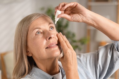 Photo of Senior woman applying eye drops at home