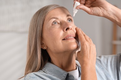 Photo of Senior woman applying eye drops at home