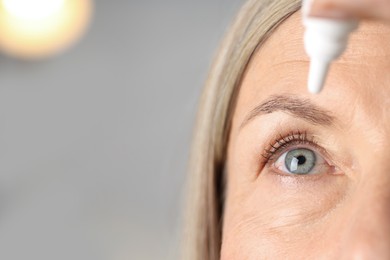 Photo of Woman applying eye drops on light background, closeup. Space for text