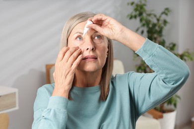 Photo of Senior woman applying eye drops at home