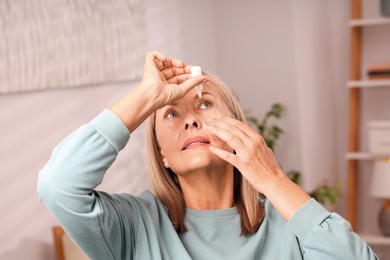Photo of Senior woman applying eye drops at home
