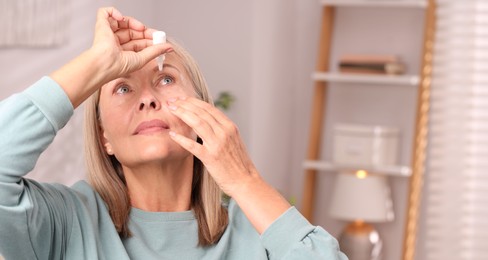 Photo of Senior woman applying eye drops at home. Space for text