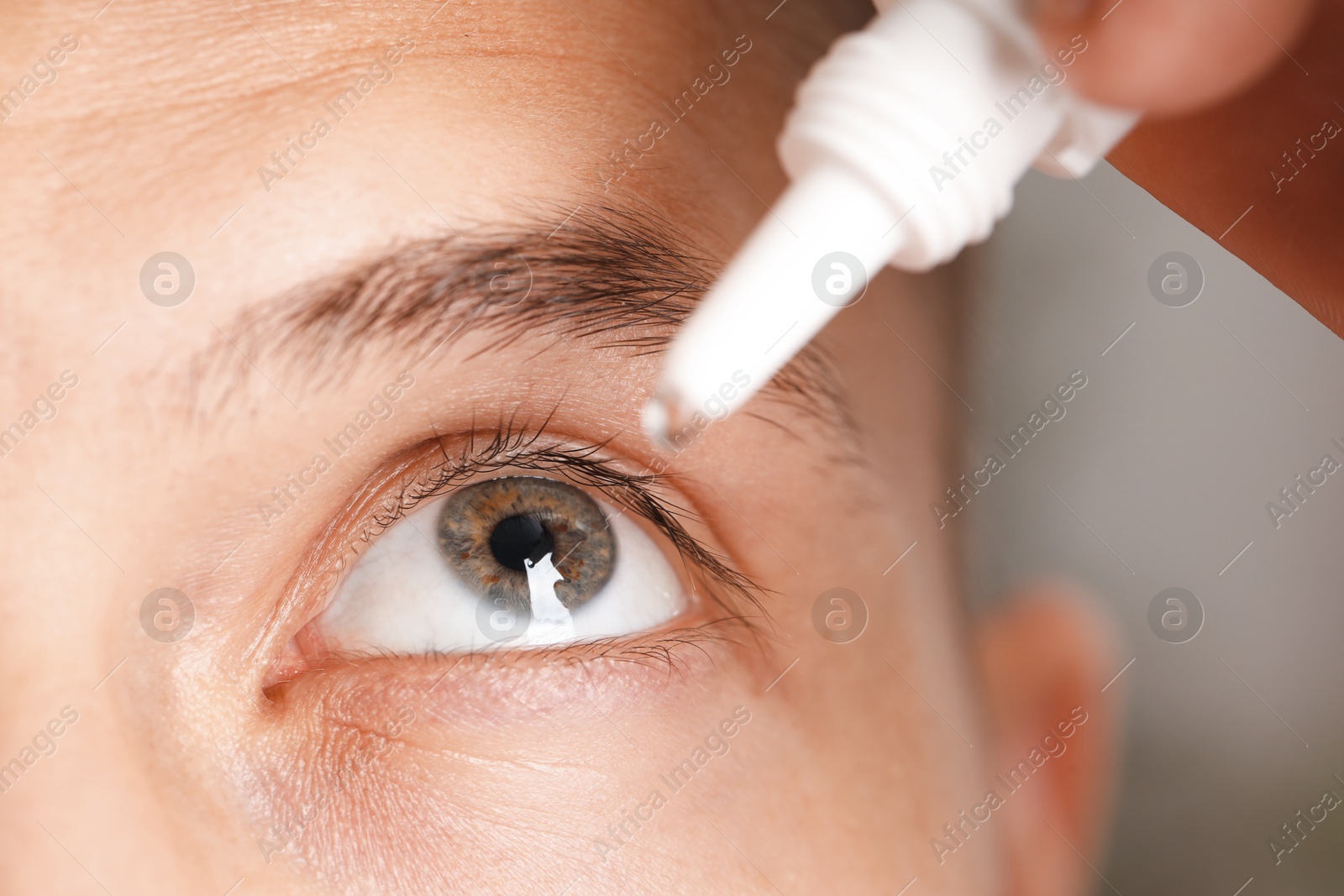Photo of Man applying eye drops on blurred background, closeup