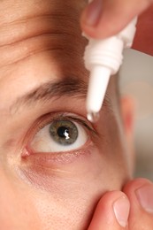 Photo of Man applying eye drops on blurred background, closeup