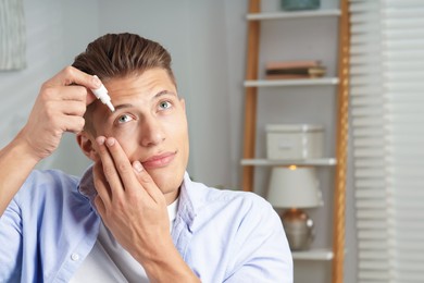 Photo of Young man applying eye drops at home. Space for text