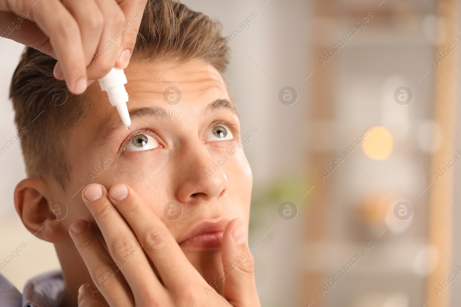 Photo of Man applying eye drops on blurred background, closeup. Space for text
