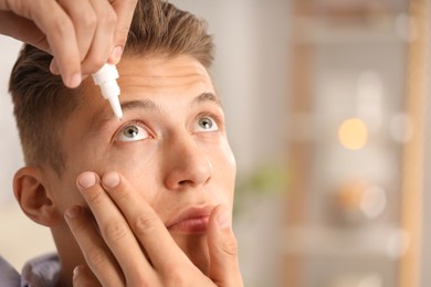 Photo of Man applying eye drops on blurred background, closeup. Space for text