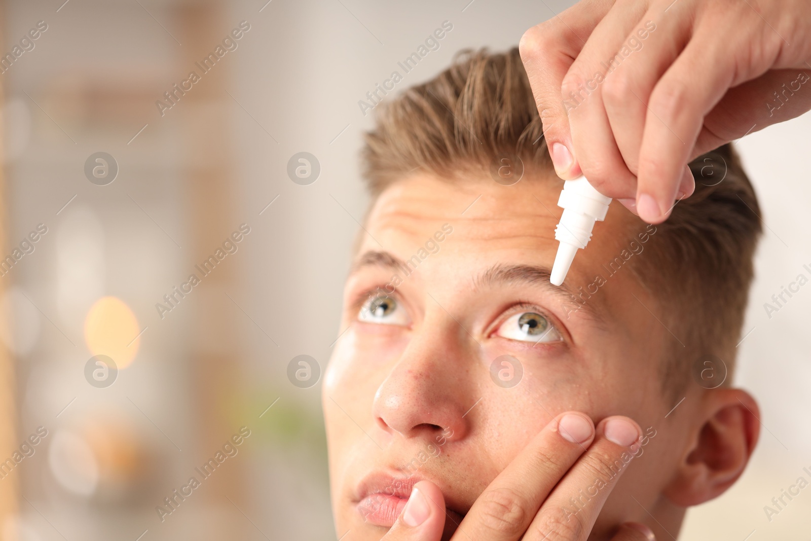 Photo of Man applying eye drops on blurred background, closeup. Space for text
