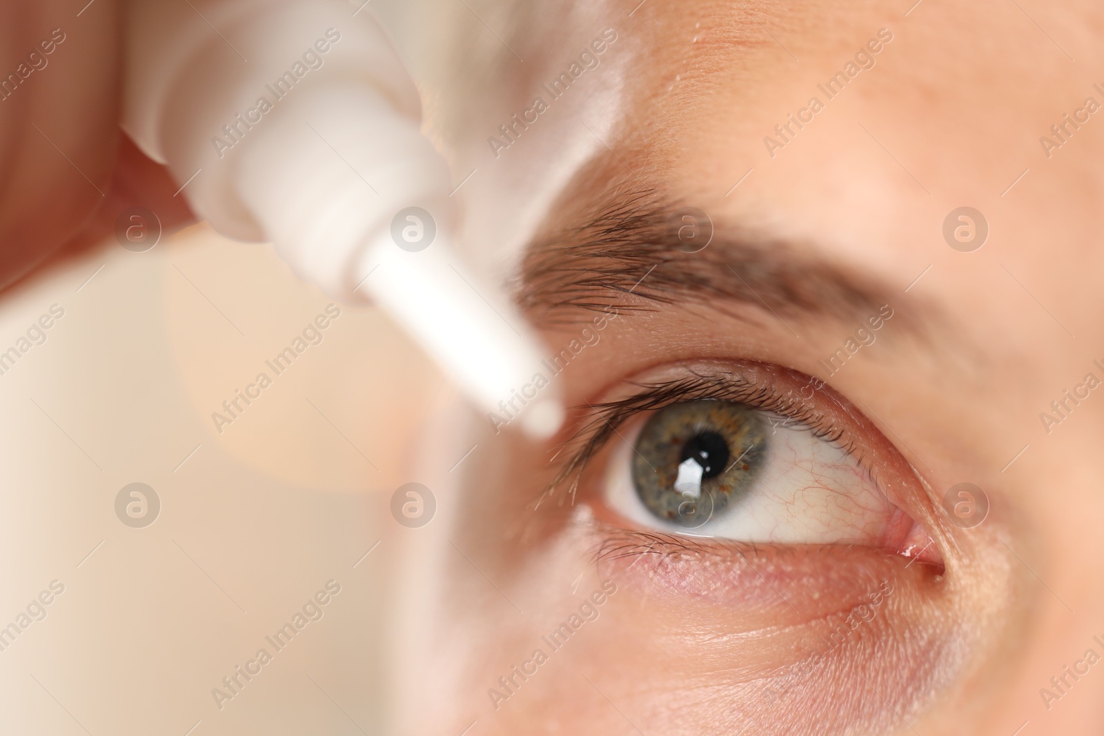 Photo of Man applying eye drops on blurred background, closeup