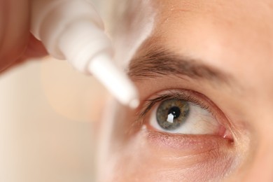 Photo of Man applying eye drops on blurred background, closeup