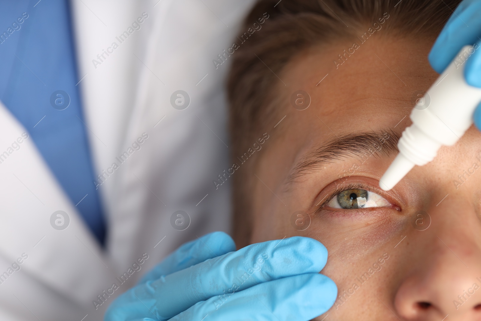 Photo of Doctor putting drops into man's eye, closeup
