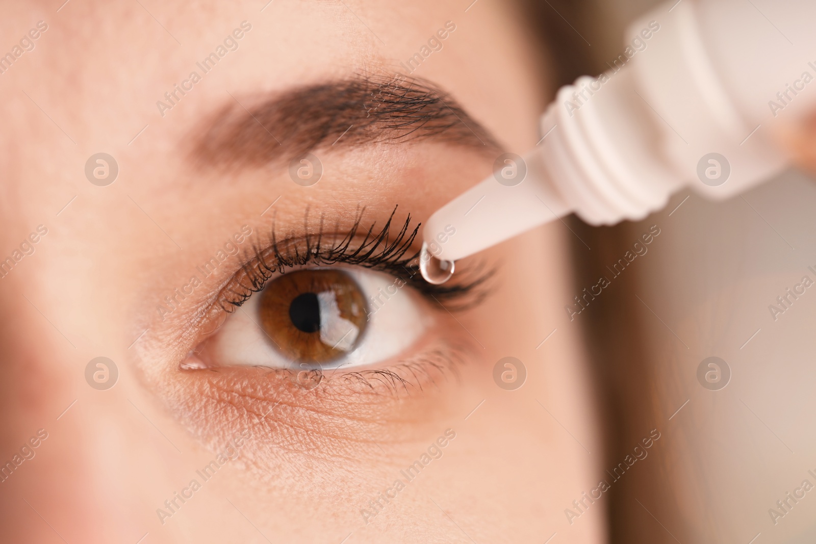 Photo of Woman applying eye drops on blurred background, closeup