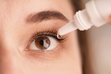Photo of Woman applying eye drops on blurred background, closeup