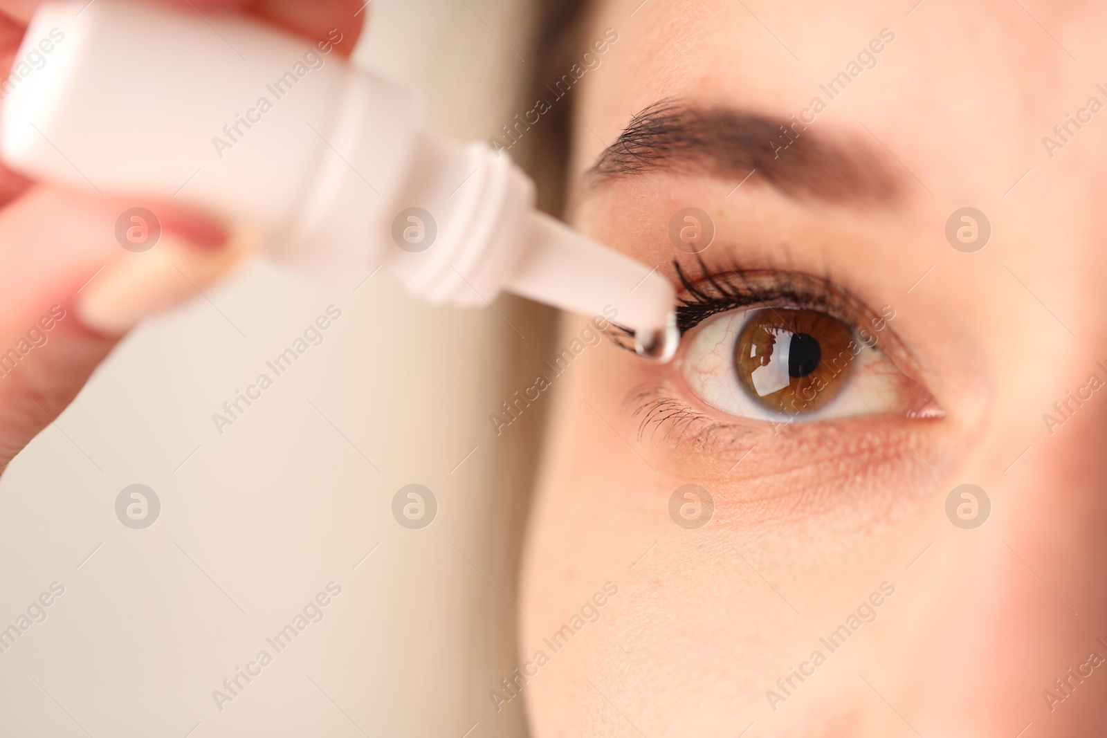 Photo of Woman applying eye drops on blurred background, closeup