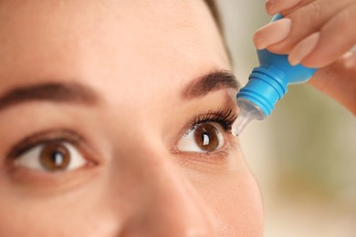 Photo of Woman applying eye drops on blurred background, closeup