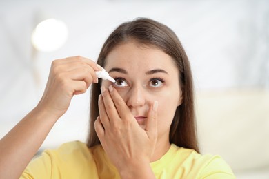 Photo of Young woman applying eye drops at home