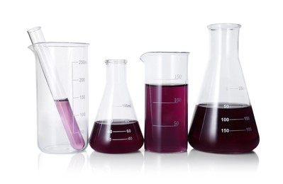 Photo of Different laboratory glassware with color liquid isolated on white