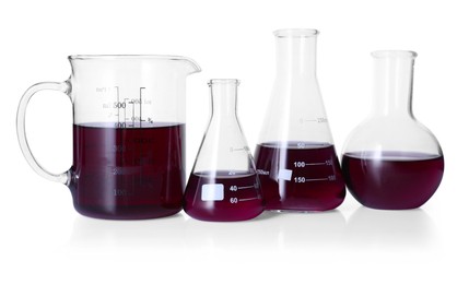 Photo of Different laboratory glassware with color liquid isolated on white