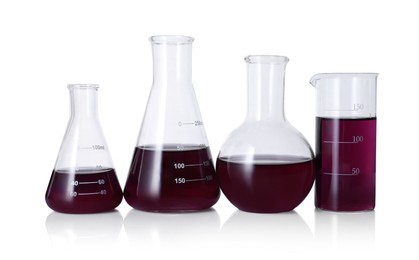 Photo of Different laboratory glassware with color liquid isolated on white