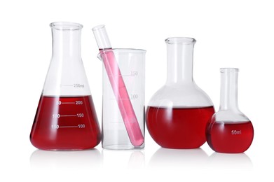 Photo of Different laboratory glassware with red liquid isolated on white