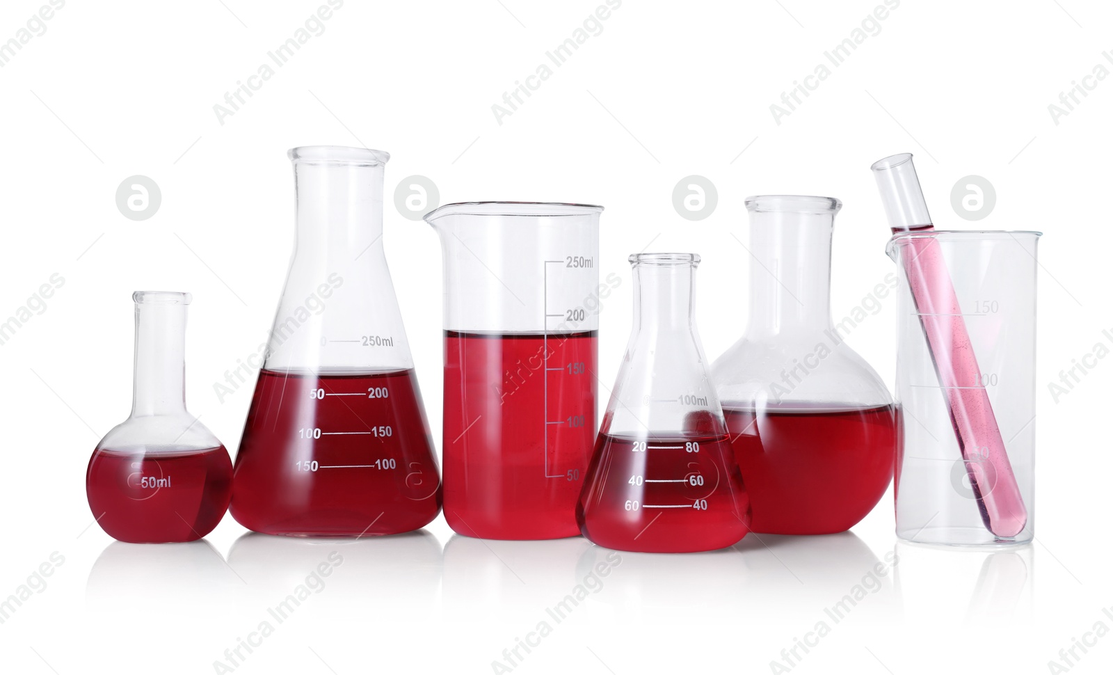 Photo of Different laboratory glassware with red liquid isolated on white