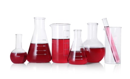 Photo of Different laboratory glassware with red liquid isolated on white