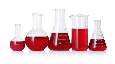 Photo of Different laboratory glassware with red liquid isolated on white