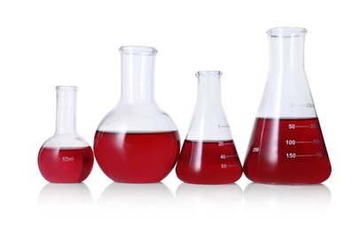 Photo of Different laboratory glassware with red liquid isolated on white