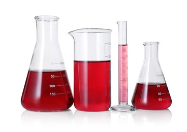 Photo of Different laboratory glassware with red liquid isolated on white